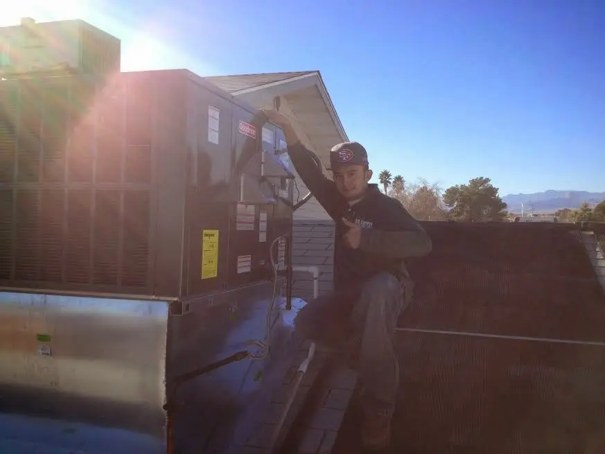 HVAC technician performing Air Duct Cleaning on a rooftop unit in Barrington